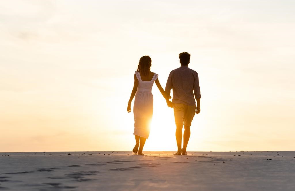 Man and woman hold hands stock photo
