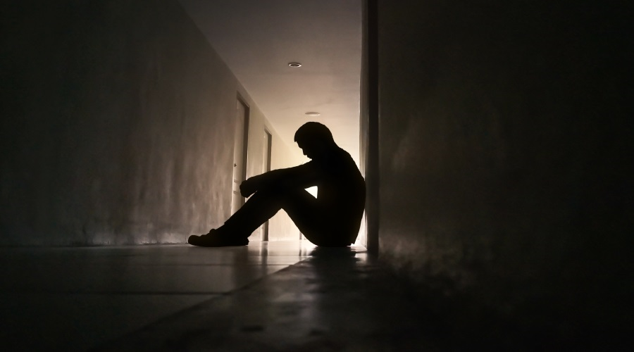 Depressed man sitting in a corridor