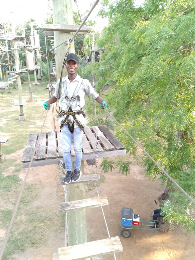 Walking on wooden boards, one of the obstacles of the High Ropes Course at the Legon Botanical Gardens